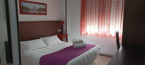 un dormitorio con una cama con dos animales de peluche en Hostal Doña Isabel, en Majadahonda