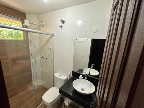 a bathroom with a toilet and a sink and a shower at Pousada Casa Natuco in Chapada dos Guimarães