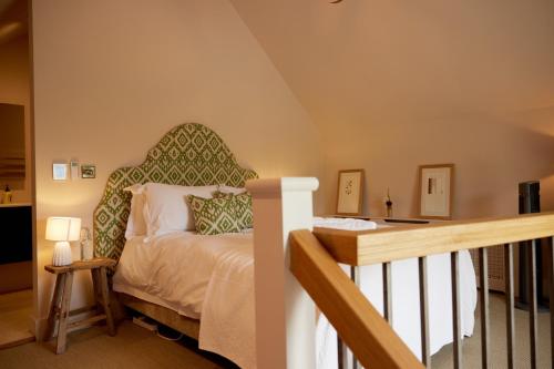 a bedroom with a bed with a green headboard at The Old Winery Cottage No1 in Shepton Mallet