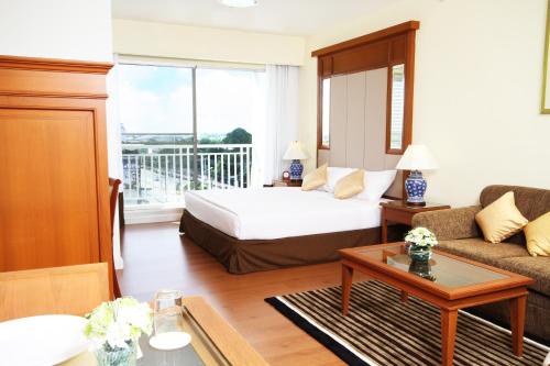 Kameo Grand Hotel & Serviced Apartment, Rayong tesisinde bir odada yatak veya yataklar