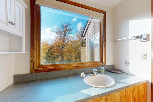 a bathroom with a sink and a large window at Mad River Masterpiece in Irasville