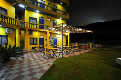 um edifício com mesas e cadeiras à sua frente à noite em Shalom Backpackers Rishikesh em Rishikesh