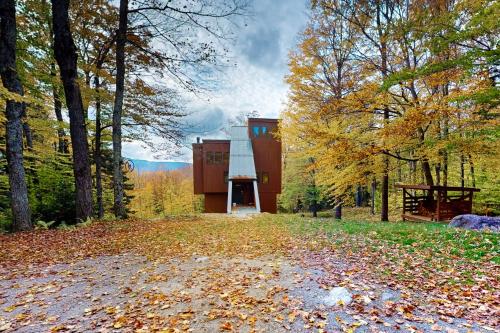 a house in the woods with leaves on the ground at Mad River Masterpiece in Irasville
