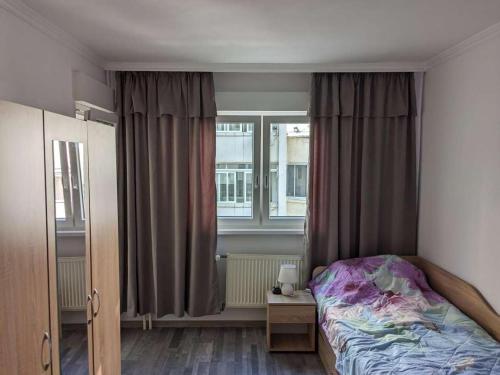 a bedroom with a bed and a window at Lazur Apartment in Burgas
