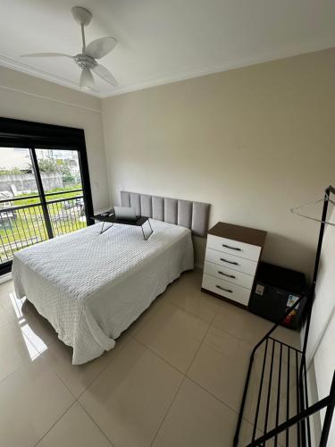 1 dormitorio con 1 cama, vestidor y ventana en Hostel APÊ DO CRIS en Florianópolis