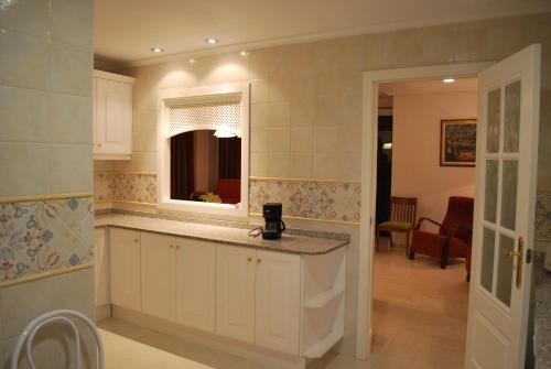 una cocina con encimera y espejo. en Apartamentos Lomas De Campoamor, en Campoamor