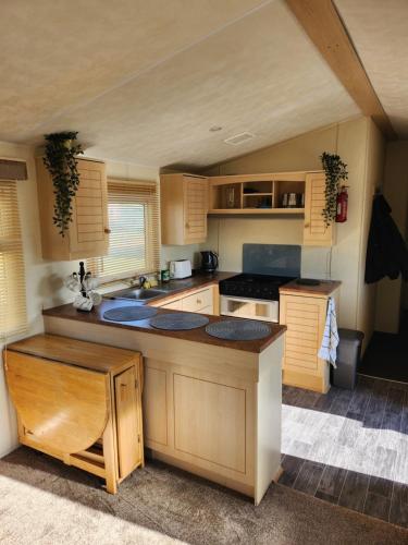 a kitchen with wooden cabinets and a counter top at sunnymede Park 6 berth at Fantasy island minimum 3 days in Ingoldmells