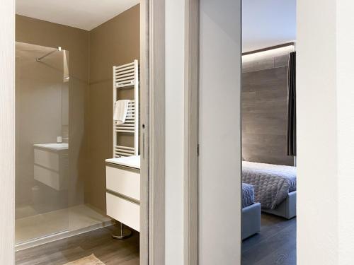 sypialnia z łóżkiem, umywalką i lustrem w obiekcie Angel's Home 2 w mieście Ponte di Legno