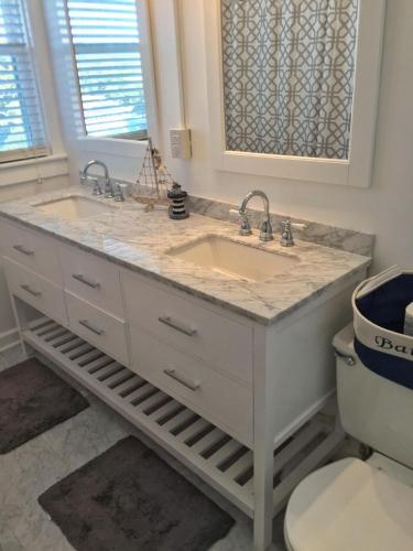 a bathroom with two sinks and a toilet at Shoreline Cottage - Oceanfront - North End VB in Virginia Beach