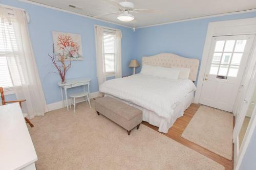 a blue bedroom with a bed and a chair at Shoreline Cottage - Oceanfront - North End VB in Virginia Beach
