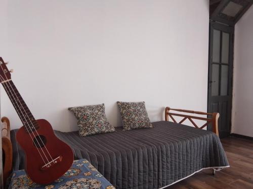 1 dormitorio con guitarra y 1 cama con guitarra en Casa Namasté en Mar del Plata