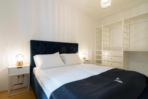 een slaapkamer met een groot bed met een blauw hoofdeinde bij Vienna Residence, Vorgartenstraße - Leopoldstadt in Wenen