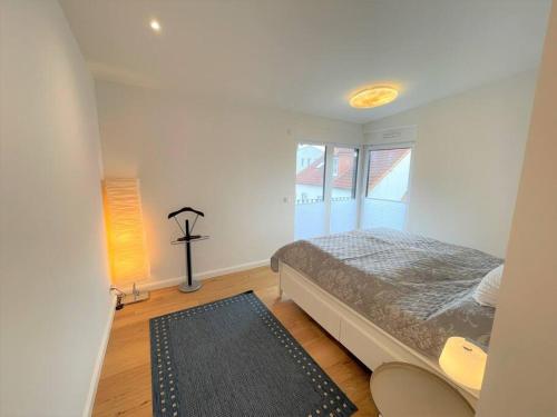 a bedroom with a bed and a window and a rug at Barrierefr. Penthouse am Hafen mit Sonnen-Terrasse in Eckernförde