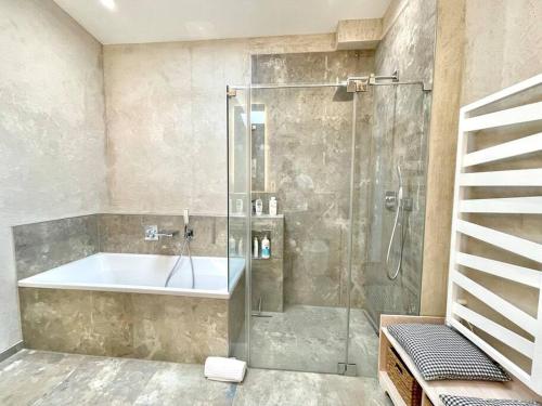 a bathroom with a shower and a bath tub at Barrierefr. Penthouse am Hafen mit Sonnen-Terrasse in Eckernförde
