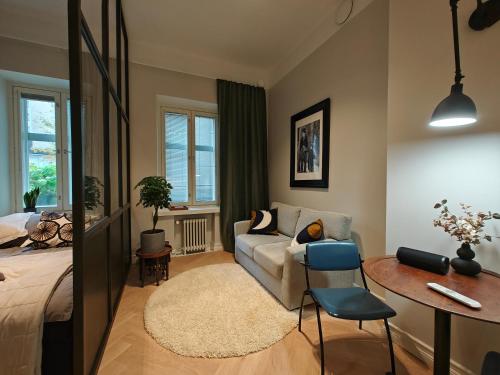 赫爾辛基的住宿－Design studio in Kamppi，一间卧室配有一张床、一张沙发和一张桌子