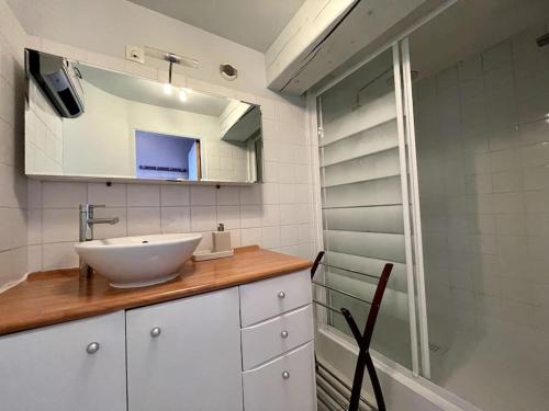 La salle de bains est pourvue d'un lavabo blanc et d'un miroir. dans l'établissement Le Belvédère de la Baie, grand gîte pour deux, à Saint-Valery-sur-Somme