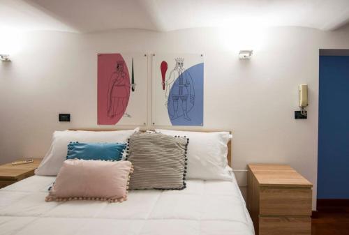 1 dormitorio con 1 cama blanca con pinturas en la pared en In Center Benni, en Palermo