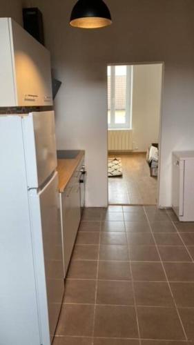 uma cozinha com um frigorífico e piso em azulejo em Appartement Cosy T3 - 2 chambres em Le Creusot