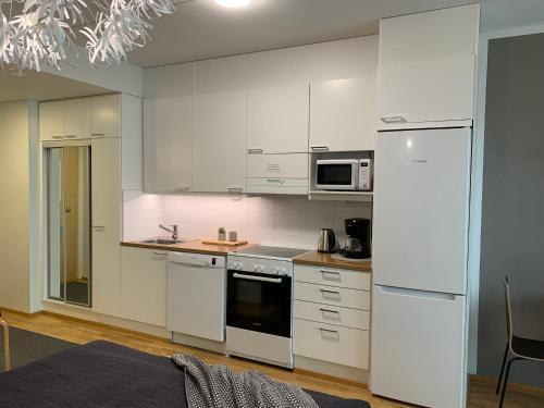a white kitchen with white cabinets and appliances at StarHomes Studio Apartments in Oulu