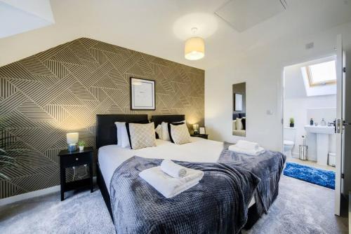 a bedroom with two beds with towels on them at 3 Bedroom House near Milton Keynes Bowl, Sleeps 6, with Free Wi-Fi, Full Kitchen, Garden and Free Parking - 1BYC in Bedford