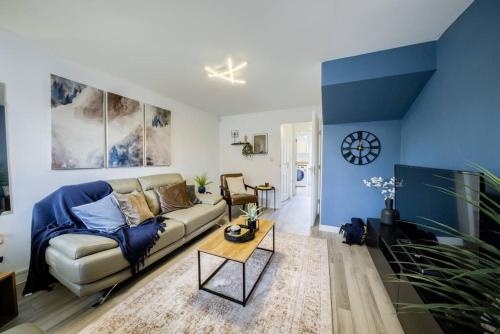 a living room with a couch and a table at 3 Bedroom House near Milton Keynes Bowl, Sleeps 6, with Free Wi-Fi, Full Kitchen, Garden and Free Parking - 1BYC in Bedford