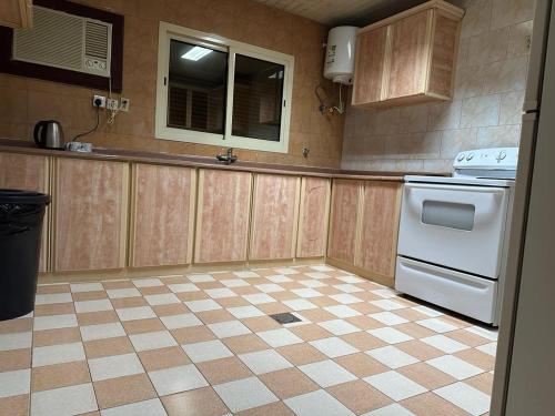 a kitchen with a white stove and a tiled floor at Al Farhan Hotel Suites Al siteen in Al Jubail