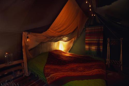 1 dormitorio con cama con dosel y ventana en Ainutlaatuinen metsämajoitus, en Enontekiö