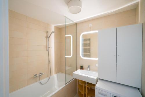 een badkamer met een douche, een wastafel en een bad bij Vienna Residence, Vorgartenstraße - Leopoldstadt in Wenen
