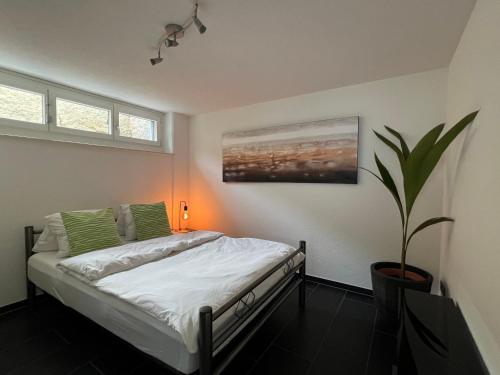 1 dormitorio con 1 cama y una maceta en The R Apartment Froburg, Parking, Netflix, Golfplatz en Obergösgen
