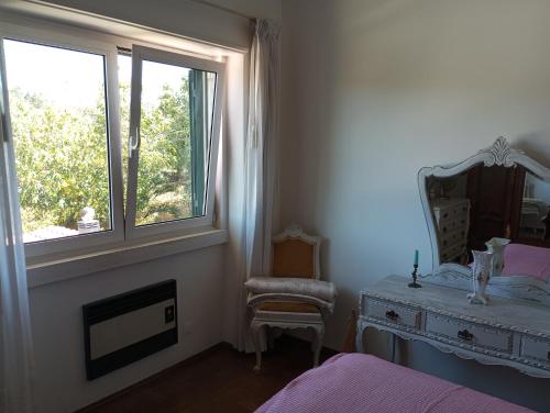 - une chambre avec un lit, un miroir et une chaise dans l'établissement Casa de alojamento local (T2) Queluz de Baixo, à Oeiras
