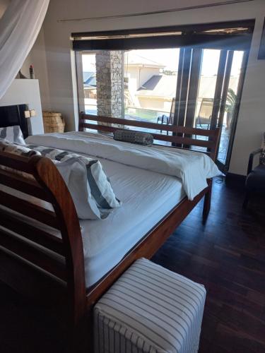 a large bed in a room with a large window at Whale Rock Guest House in Plettenberg Bay