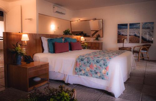 a hotel room with a large bed and a table at Sun City Rota das Emoções in Camocim