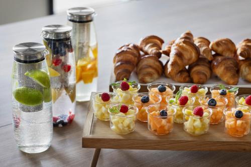 a table with a tray of pastries and fruit in cups at Courtyard by Marriott Biel Bienne in Biel