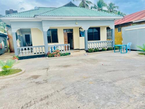 a house with a blue table in front of it at CLASSIC VISITORS HOUSE in Nasulo