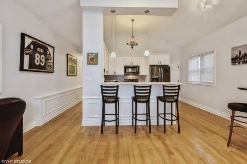 a kitchen with a bar with stools in a room at 2-Bed 2-Bath Apt - Close to UC w/ Free Parking in Chicago