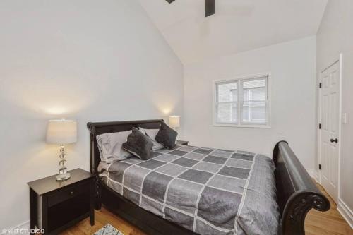 a bedroom with a bed and a table with a lamp at 2-Bed 2-Bath Apt - Close to UC w/ Free Parking in Chicago