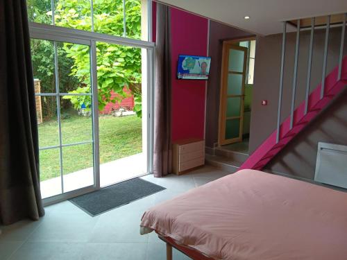 a bedroom with a bed and a large window at LA BARAQUE 