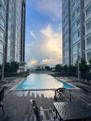 a swimming pool in the middle of two tall buildings at Rayyan Condominium @ Metrocity Square in Kuching