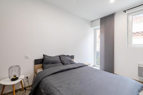 sypialnia z łóżkiem, stołem i oknami w obiekcie Idéal couples & pro - Patio extérieur- Proche centre ville et gare - Promenade au bord de la Charente - Parking à proximité - Wifi très haut debit - Équipement premium -Netflix w mieście Angoulême