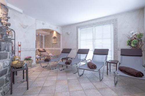 a room with chairs and a table and a fireplace at Patteriol Apart-Hotel-Garni in Sankt Anton am Arlberg