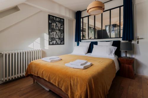 een slaapkamer met een bed met twee handdoeken erop bij Loge du Pré Carré - hypercentre in Annecy