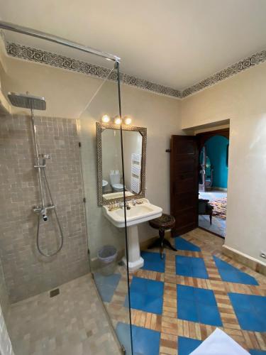 a bathroom with a shower and a sink and a mirror at Riad El Arsat & Spa in Marrakech