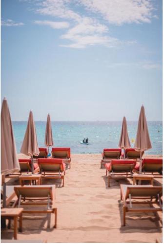 a row of chairs and umbrellas on a beach at Kon Tiki in Saint-Tropez