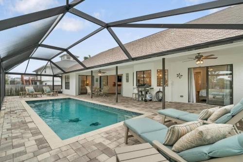 a house with a swimming pool with a roof at Tahiti Cottage in Marco Island