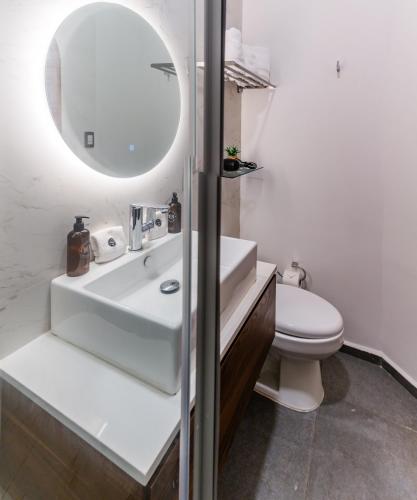a bathroom with a sink and a toilet and a mirror at Casa Castillo in Mexico City
