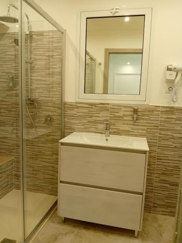 a bathroom with a sink and a shower and a mirror at Al Punto Giusto in Catania