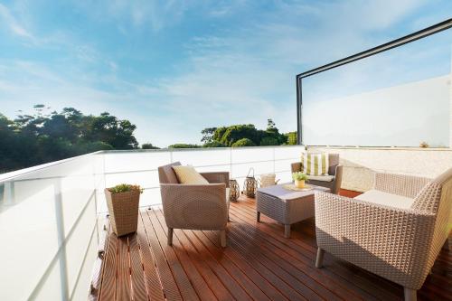 terraza con sillas y mesa en el balcón en Magníficos Dias Atlânticos, en Moledo