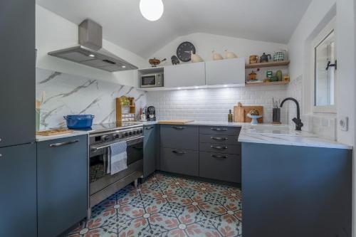 a kitchen with gray cabinets and a stove top oven at Villa Vauvert in Saignon