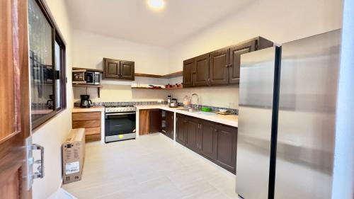 a kitchen with wooden cabinets and a stainless steel refrigerator at Casa Puerto Viejo in Puerto Escondido