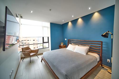 1 dormitorio azul con 1 cama y 1 silla en Luxury suite in La Carolina, en Quito